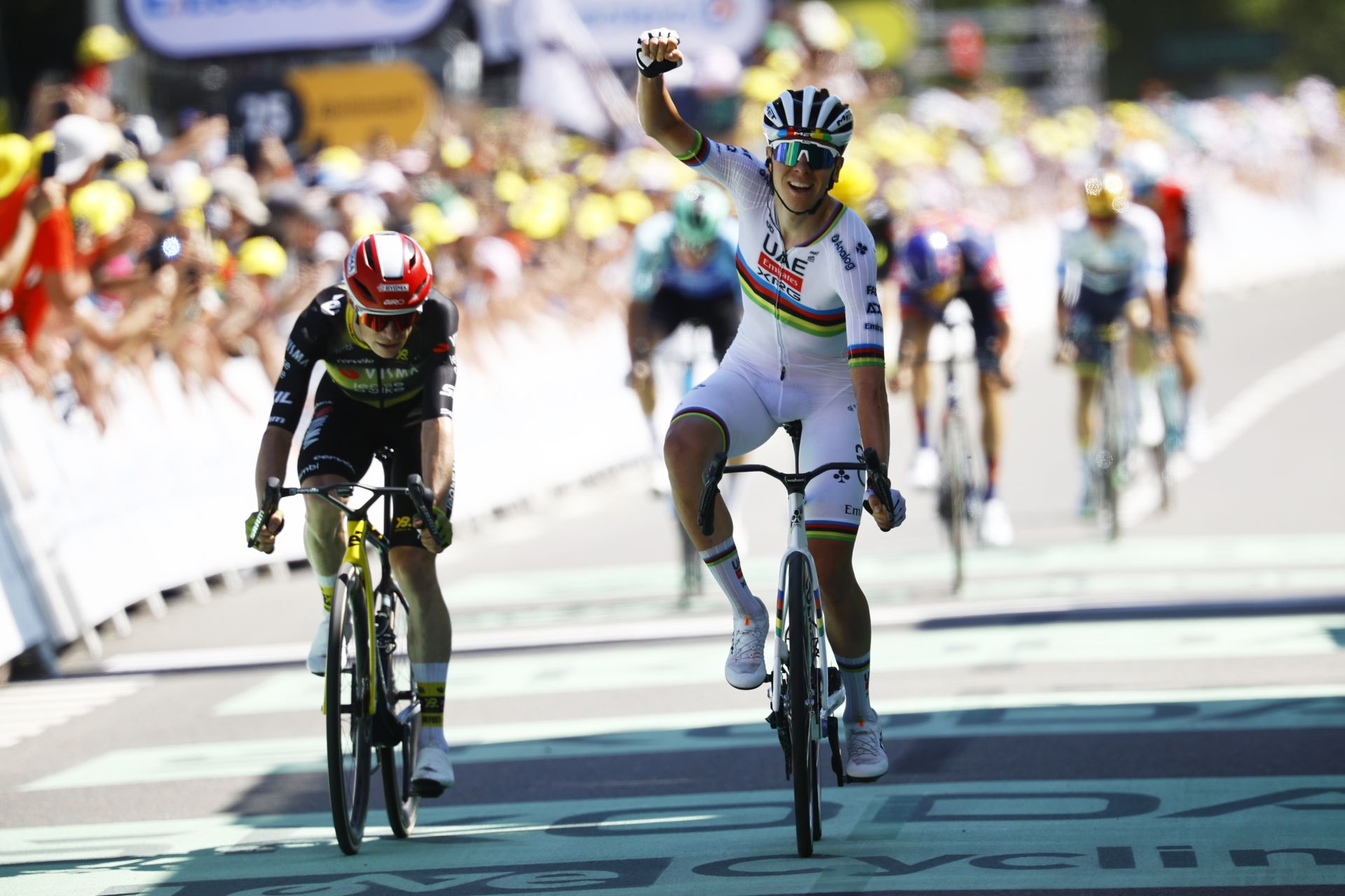 Pogacar levanta el brazo tras imponerse en la meta del Muro de Bretaña.