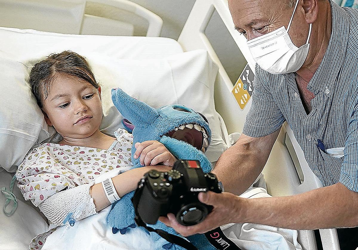 La pequeña Leire en su cama del hospital de Cruces junto a su abuelo.