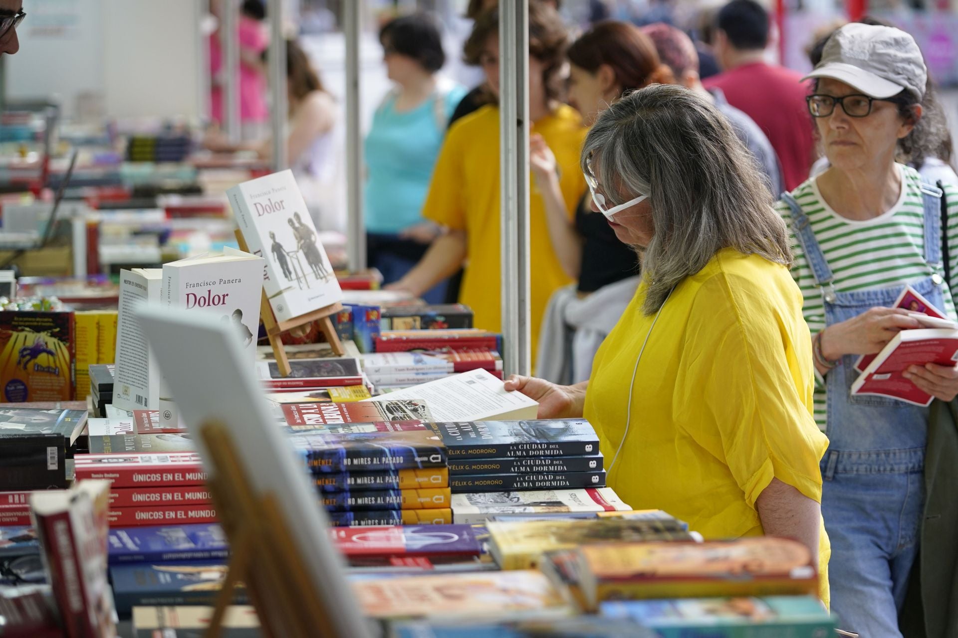 Una mujer ojea un ejemplar en una feria celebrada en una anterior edición.