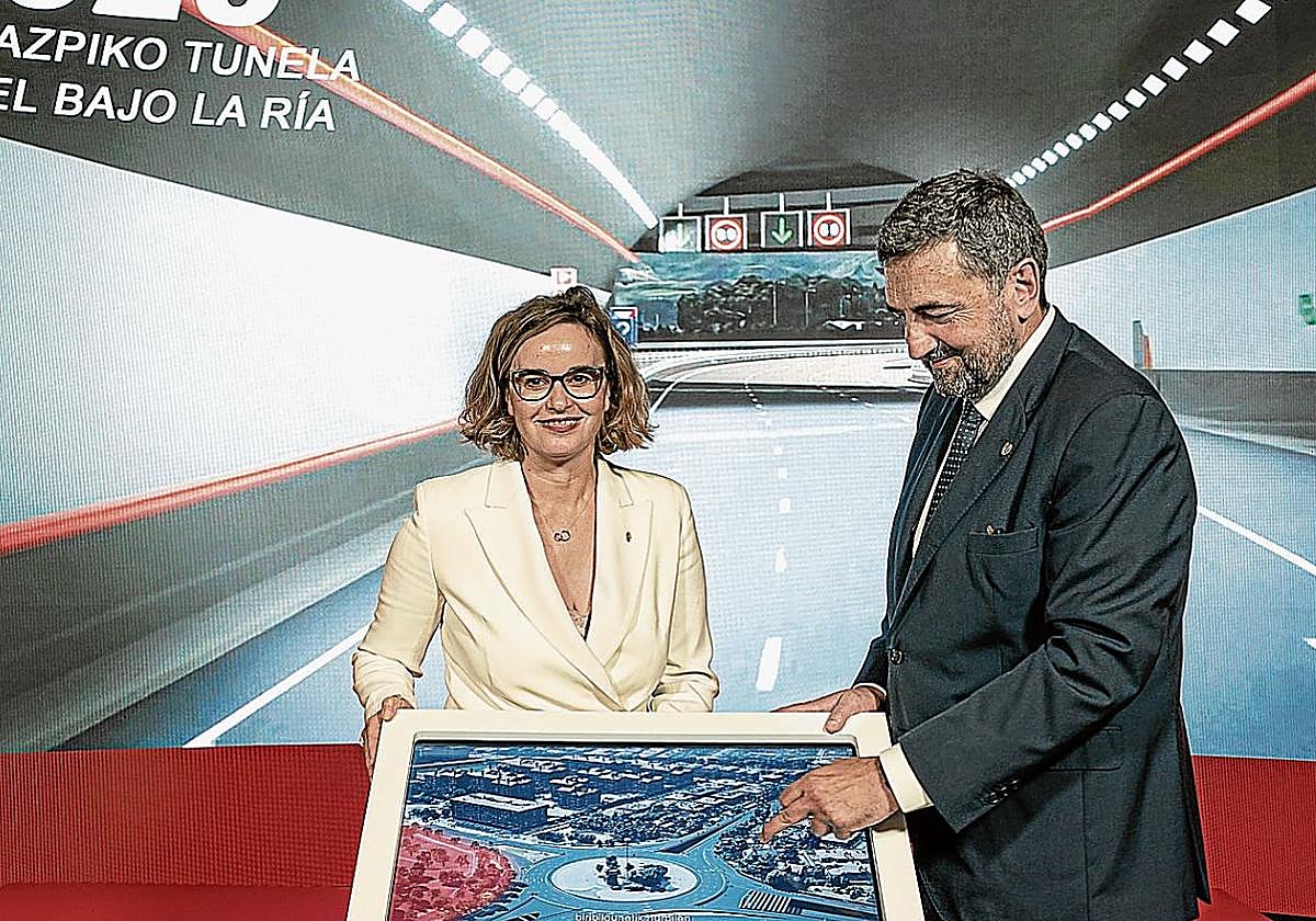 Elixabete Etxanobe y el diputado de Infraestructuras, Carlos Alzaga, muestran una infografía del futuro entorno de Artaza, una vez esté concluido el subfluvial.