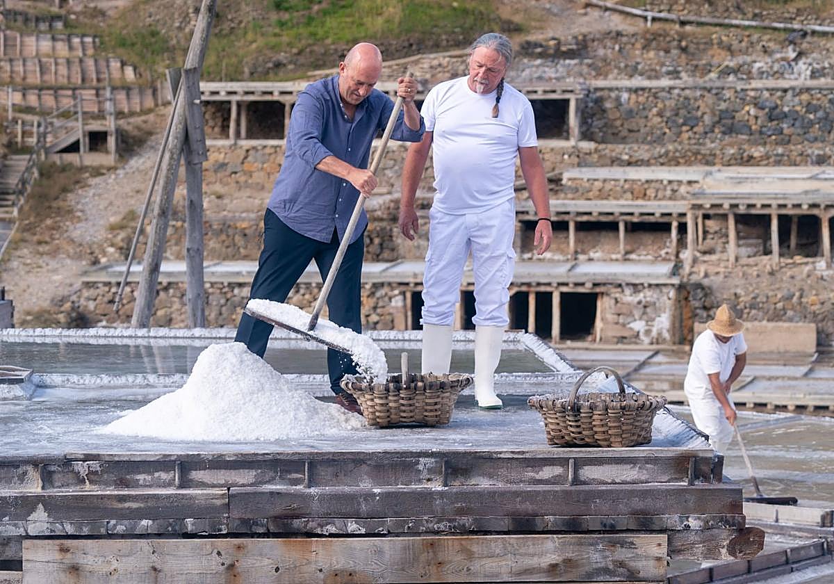 Aitor Arregi recoge sal junto a un maestro salinero.