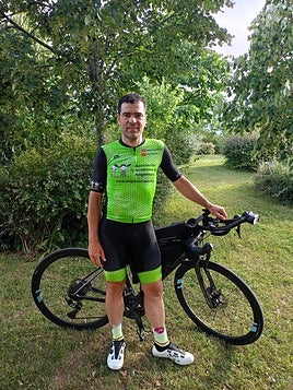 El ciclista posa con el maillot conmemorativo del Síndrome de Angelman y su bicicleta.