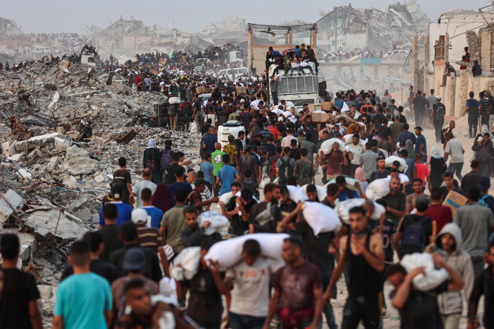 Los palestinos se agolpan en un sendero costero al oeste de Beit Lahia después de lograr obtener paquetes de ayuda