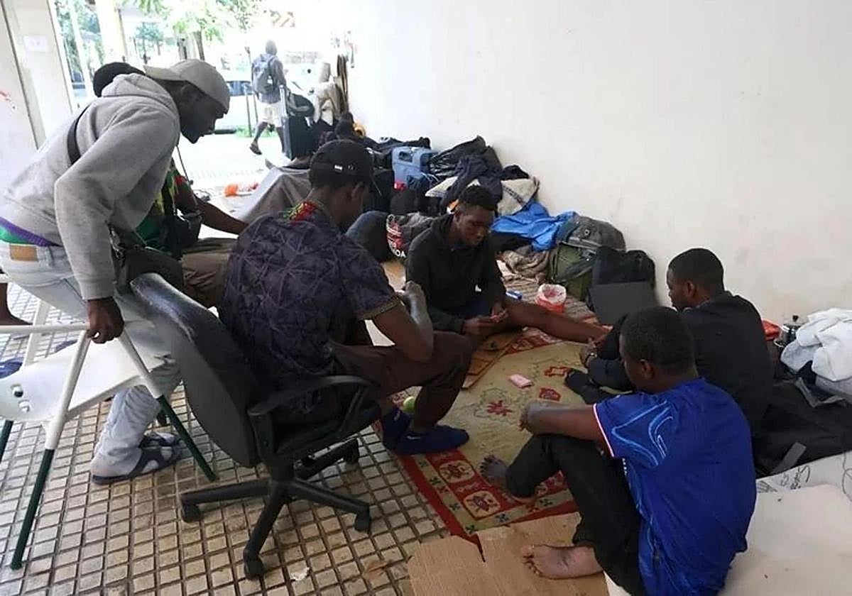 Un grupo de malienses mata el tiempo jugando a las cartas en los soportales donde están asentados en la plaza Cofradías Donostiarra (San Sebastián).