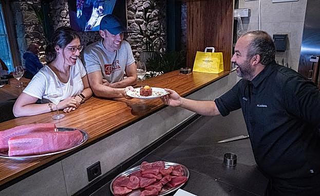 Alex Duke sirve un plato de tartar de yellowfin a unos visitantes de Alakrana.