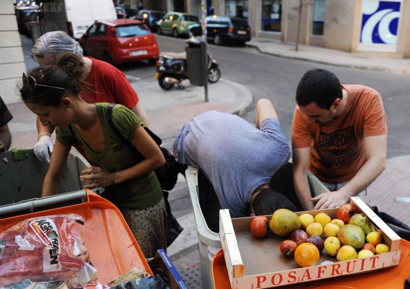 Activistas del grupo «Comida Basura», que busca concienciar sobre el desperdicio de alimentos, seleccionan frutas y verduras de los cubos de basura. Madrid 2012 .