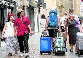 En el Casco Viejo. Turistas acarrean sus maletas por la zona histórica de Bilbao durante la calurosa jornada de ayer.