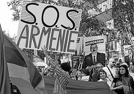 Un manifestante sostiene un cartel que dice «S.O.S Armenia» mientras otros ondean banderas armenias durante una manifestación en apoyo a los armenios en Bruselas, el 1 de octubre de 2023.