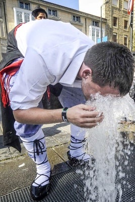 Unos blusas se refrescan en una calle de Vitoria.