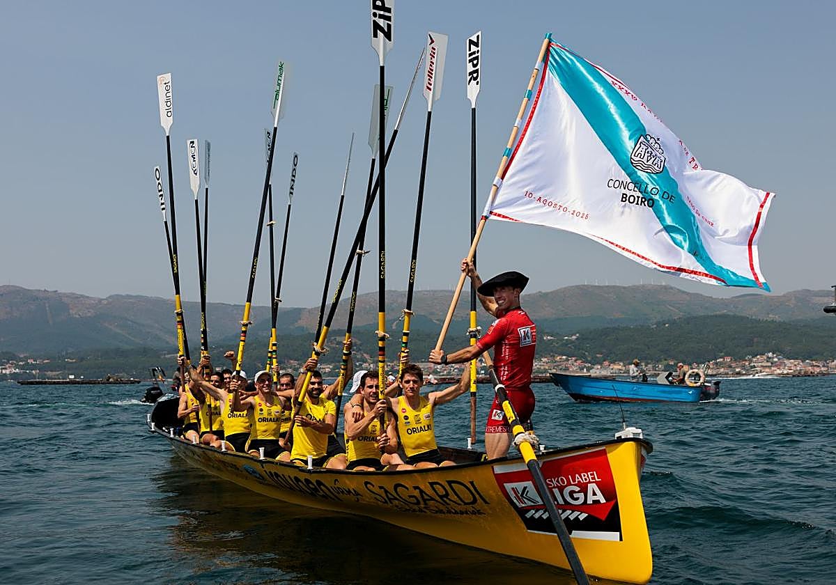 La tripulación de Orio saluda a la afición con los remos en alto tras imponerse en la Bandera de Boiro.
