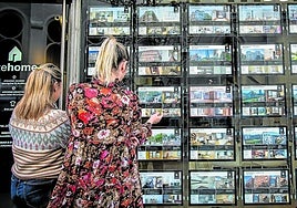Dos mujeres observan el escaparate de una inmobiliaria. Estas han canalizado en vivienda usada ocho de cada diez ventas.