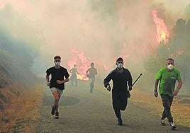 Asediados. Granjeros huyen del avance incontenible de las llamas que se extienden por Larouco, en Ourense.