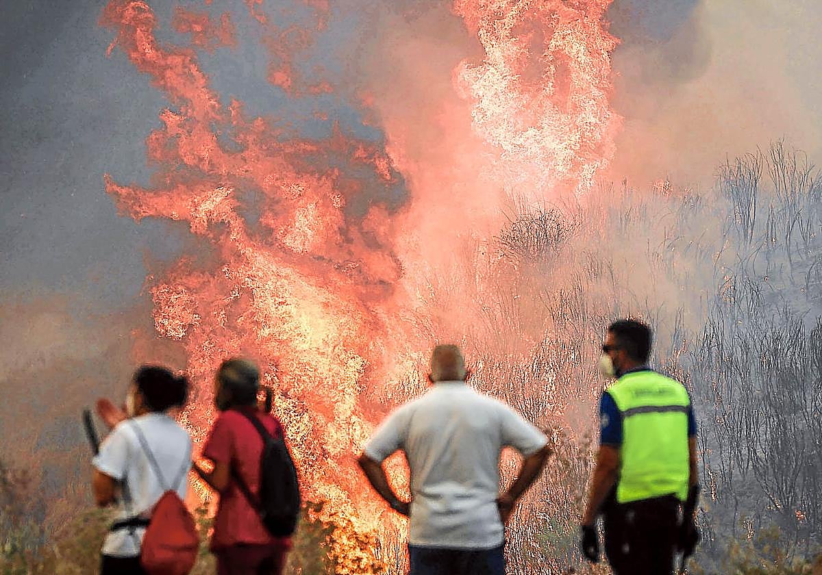 Varias personas asisten impotentes al avance de las llamas del incendio de A Gudiña (Ourense).