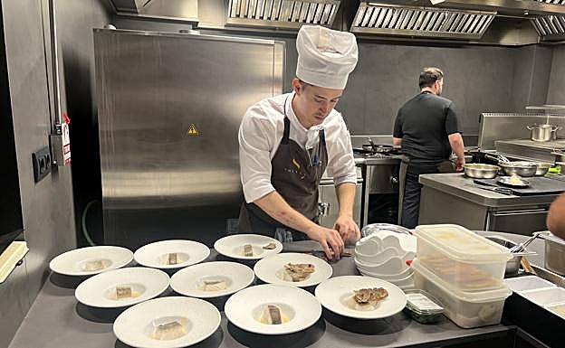 Lucas prepara varios platos del pescado del menú degustación.