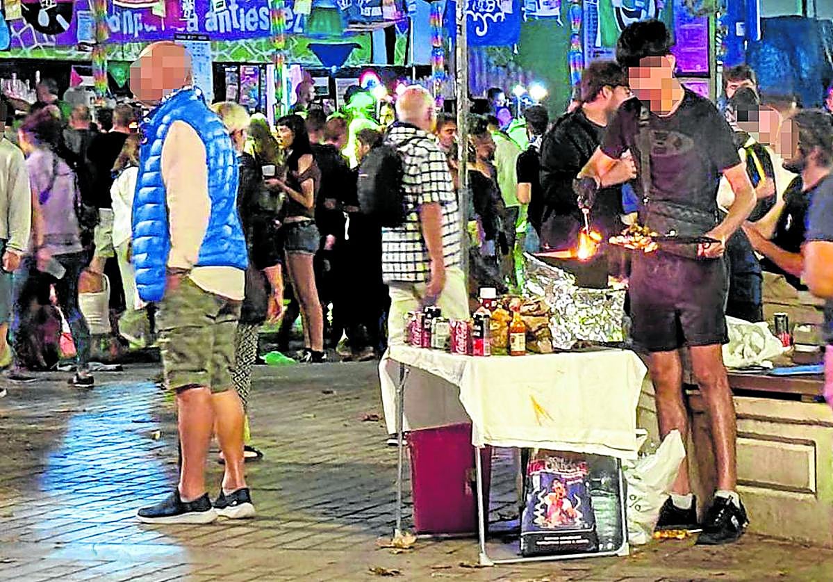 Un joven cocina carne en una parrilla improvisada en El Arenal la noche del lunes al martes, en la que el Ayuntamiento desplegó un dispositivo contra esta actividad.