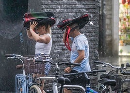 Dos personas se protegen de la lluvia en Vitoria.
