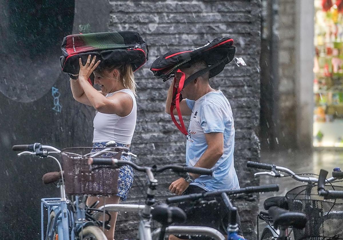 Dos personas se protegen de la lluvia en Vitoria.