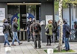 Un grupo de personas hace cola para acceder a una oficina de Lanbide.