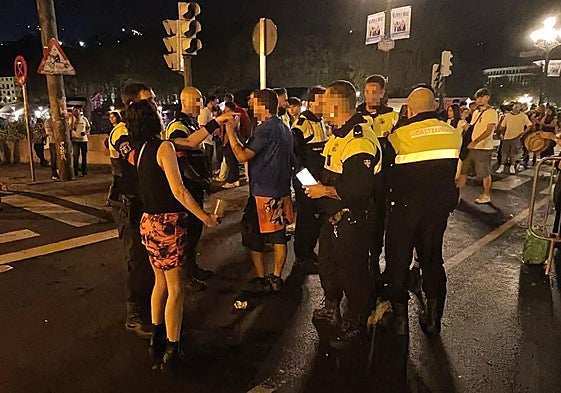 Policías municipales atienden a un joven que ha sufrido un robo con violencia y a sus amigos en la calle Navarra de Bilbao.