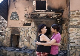 Dos vecinas se abrazan tras el incendio que ha asolado San Vicente de Leira, en Ourense.