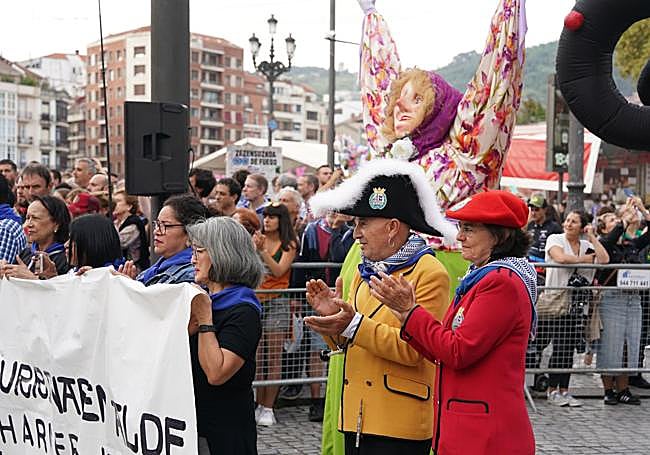 Francis Díez y Olatz Agirre pasan frente a Marijaia durante un acto de homenaje a la ikurriña.
