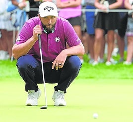 Rahm prepara un tiro en el green en su partido contra Mickelson.