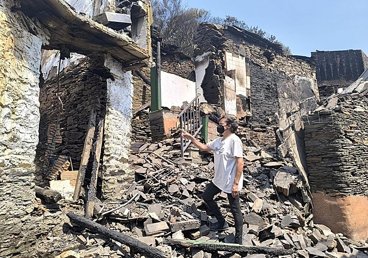 Cristina Rodríguez, de Sestao, muestra el estado en el que ha quedado una de las casas arrasadas por las llamas en la aldea de Cernego.