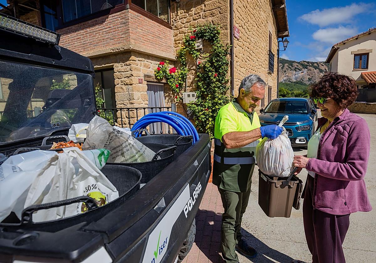 Una vecina de Kripan entrega sus desperdicios a un empleado.