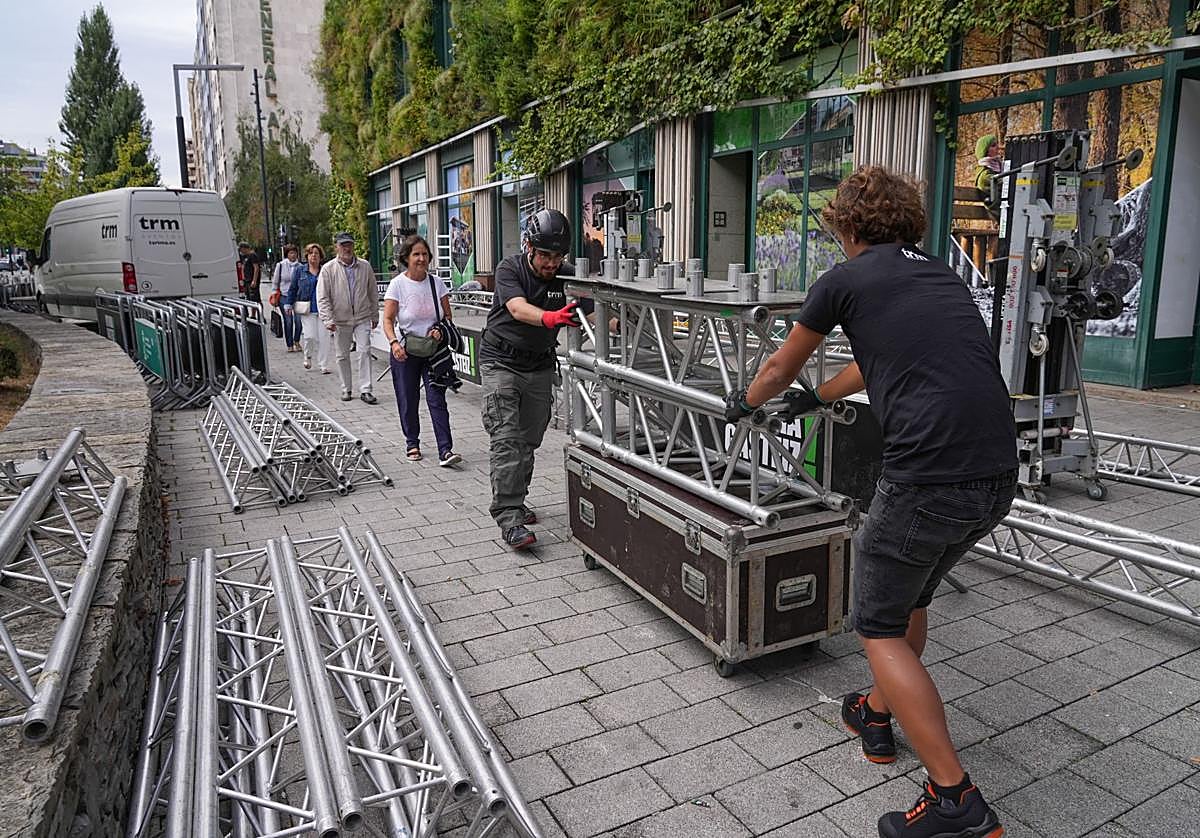 Un par de operarios durante el montaje en el exterior del Palacio Europa, donde se concentrarán todos los actos.