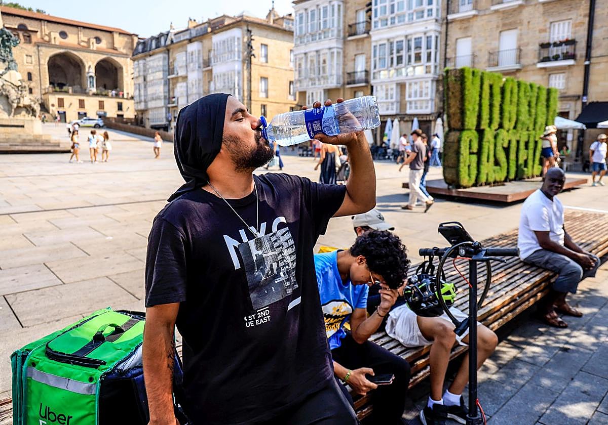 Un hombre se refresca en la plaza de la Virgen Blanca de Vitoria.