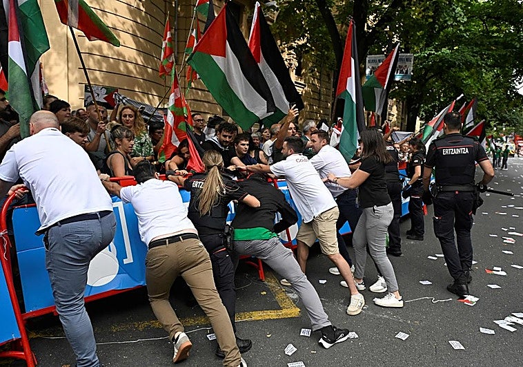 El personal de la Vuelta y agentes de la Ertzaintza mantienen barreras mientras manifestantes propalestinos se manifiestan durante la undécima etapa de la Vuelta a España en Bilbao.