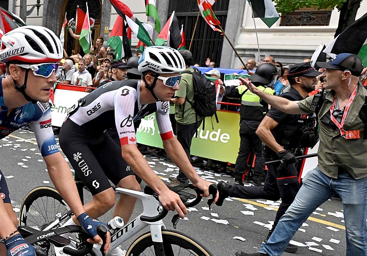 Ciclistas compiten mientras manifestantes pro-palestinos con banderas palestinas y vascas se manifiestan durante la undécima etapa de la Vuelta a España.