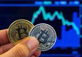 Una persona con la representación de un Bitcoin, una criptomoneda.