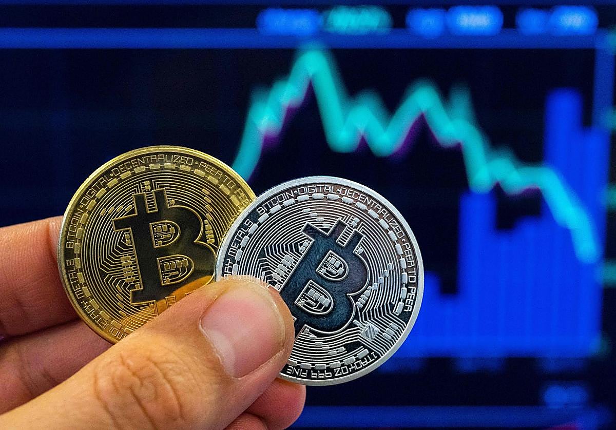 Una persona con la representación de un Bitcoin, una criptomoneda.