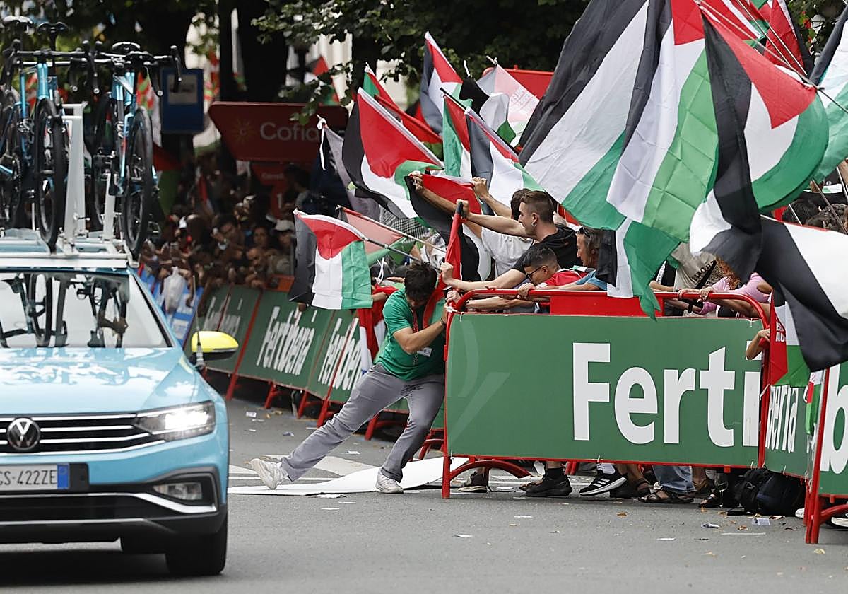 Un miembro de la organización trata de contener a los manifestantes antes de que se cancelase el final.