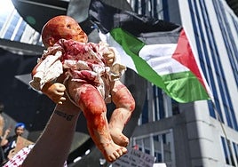 Una persona levanta una muñeca pintada de rojo como parte de la protesta «Dibuja la línea roja para Gaza» contra las operaciones militares de Israel en la Franja de Gaza y en apoyo al pueblo palestino, en Bruselas.