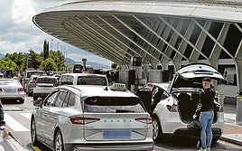 Taxistas recogen a turistas en la parada del aeropuerto de Loiu.