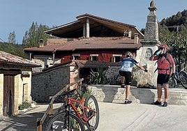 Dos ciclistas recuperan energías en la fuente de Cogullos.