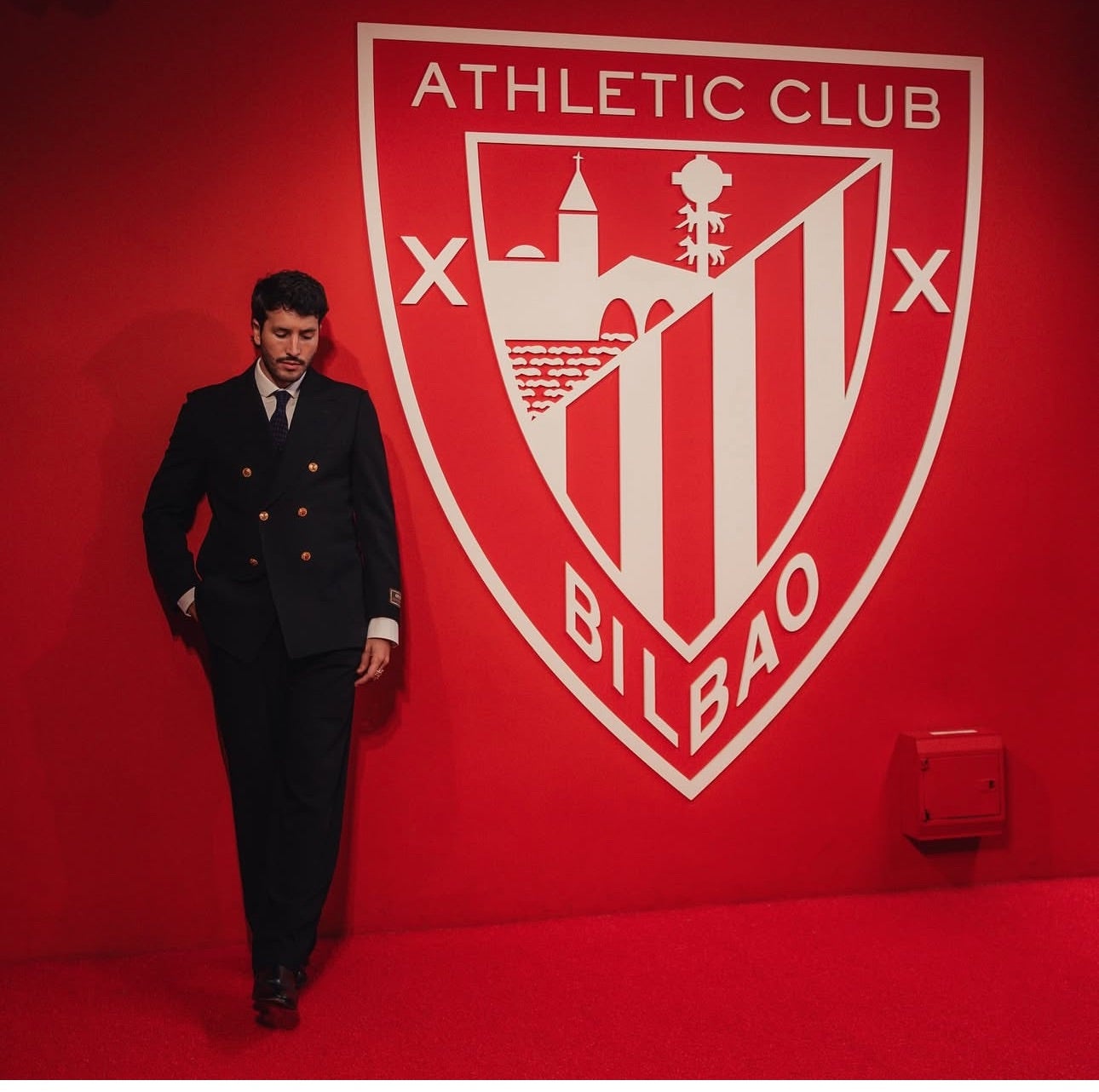 Yatra posa con mucho respeto y solemnidad junto al escudo del Athletic, en San Mamés.