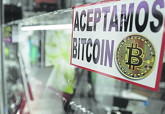 Imagen de un establecimiento con un cartel en el que se indica que se aceptan bitcoins.