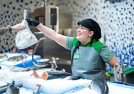 Una trabajadora de la sección de pescadería de Mercadona atiende a un cliente.