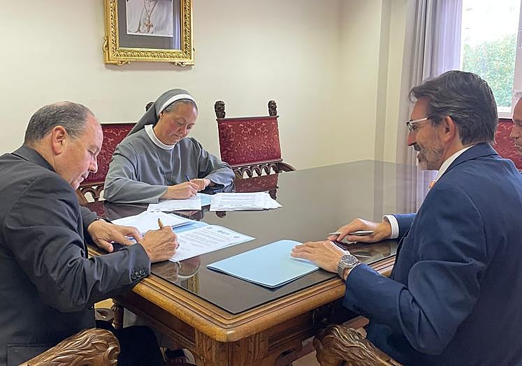 La directora del colegio firma el documento junto al Obispo de Vitoria y al representante de la entidad colaboradora.