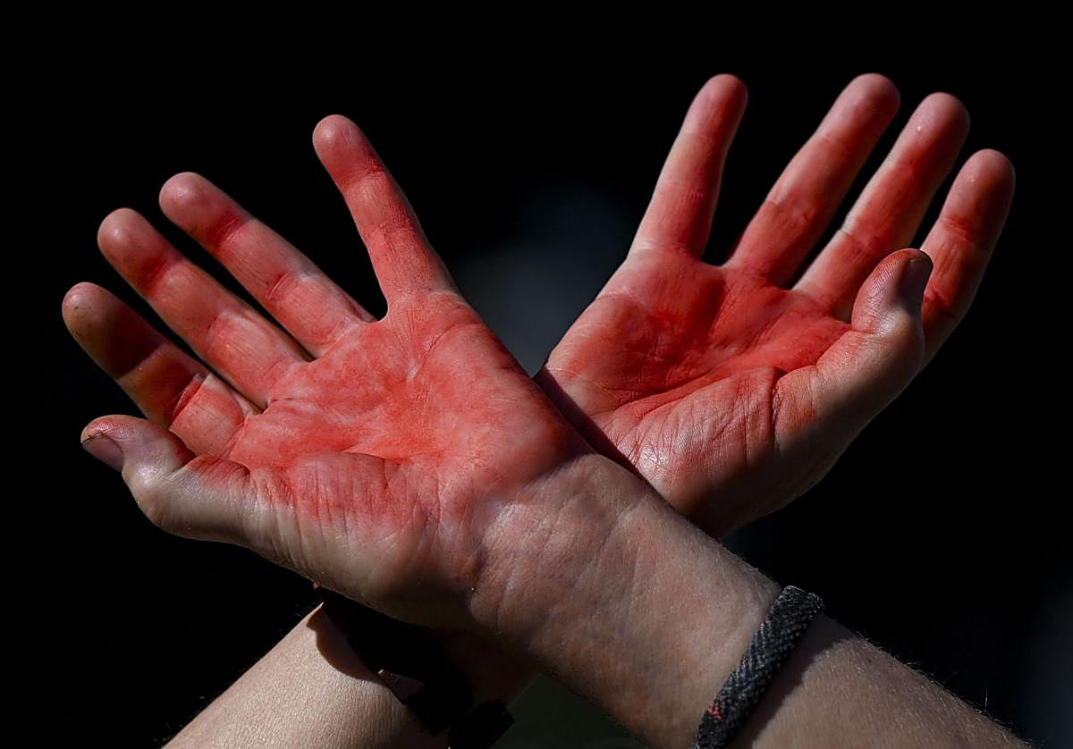 Manos pintadas de rojo, símbolo de manos ensangrentadas, durante la protesta «Dibuja la línea roja para Gaza» contra las operaciones militares de Israel en la Franja de Gaza y en apoyo del pueblo palestino, en Bruselas, Bélgica.