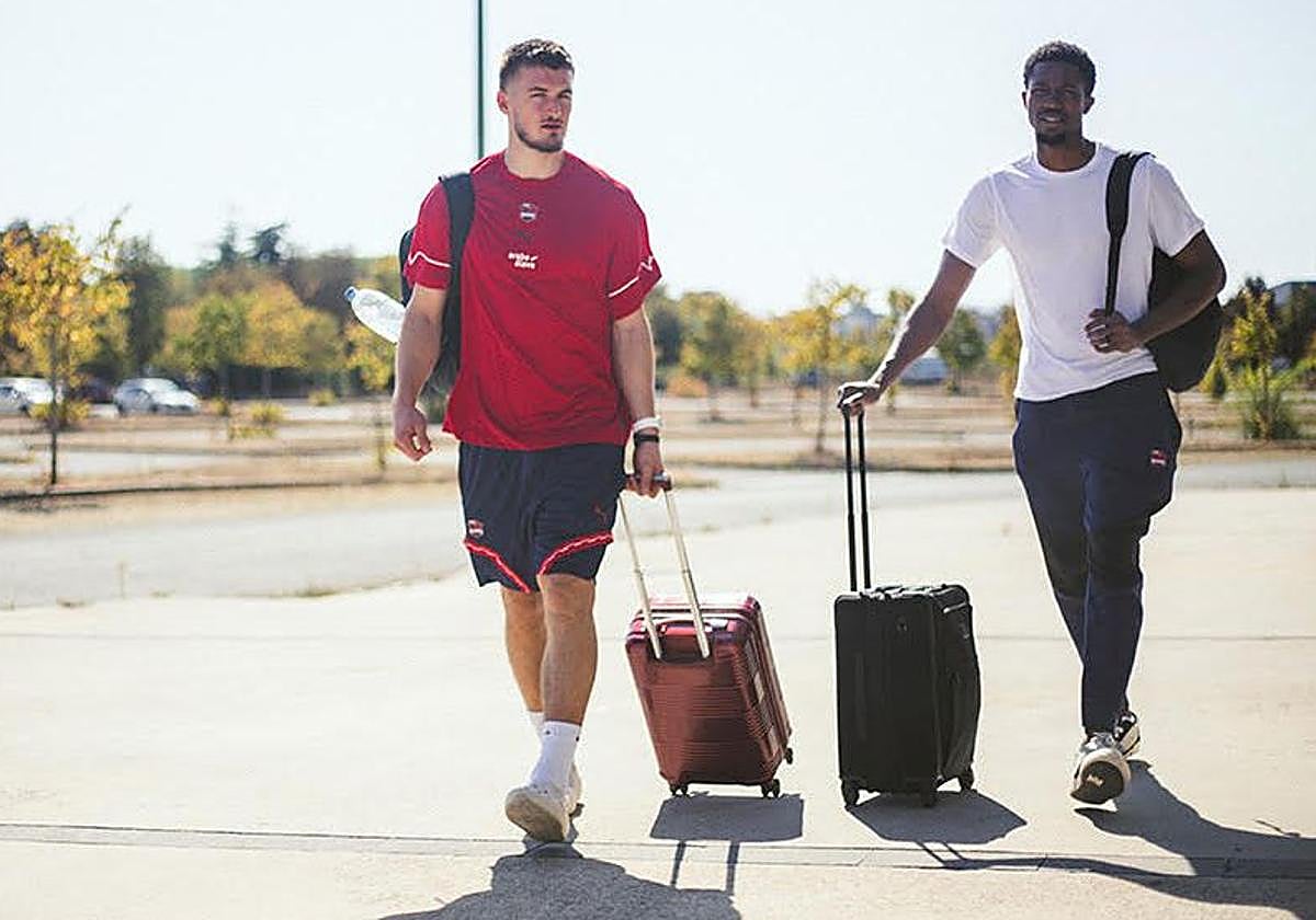 Clement Frisch y Hamidu Diallo caminan hacia el autobús azulgrana con sus maletas.