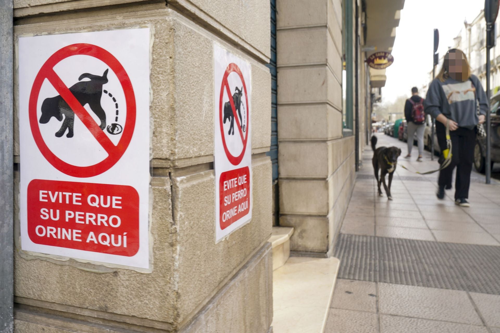 Cartel que advierte a los propietarios de perros para que no orinen en las fachadas de un edificio de Vitoria.