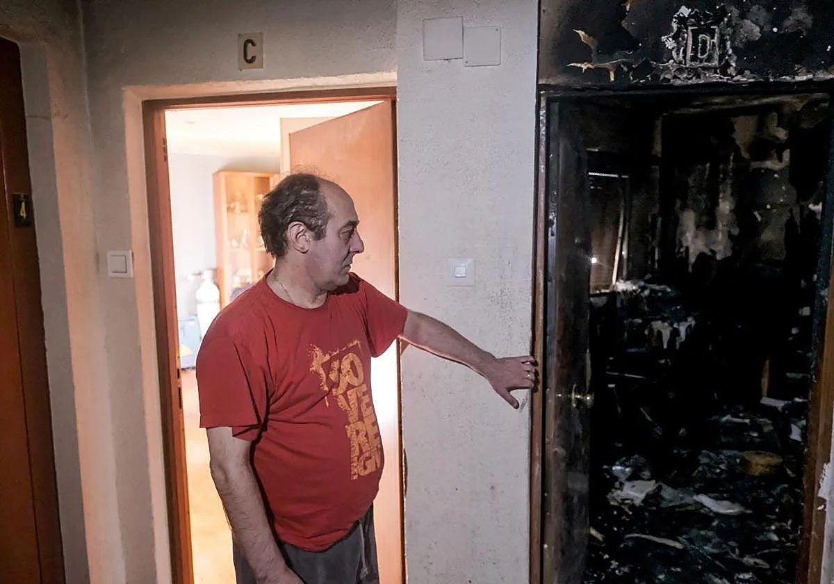 Javi Martínez señala desde la puerta de su casa la vivienda calcinada donde residía el fallecido