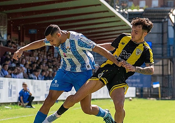 Eric Pérez trata de robar un balón a un jugador del CF Talavera de la Reina.