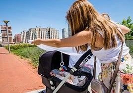 Una mujer protege del sol a su bebé.