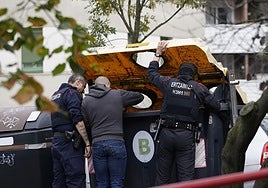 Investigadores de la Ertzaintza tratan de localizar el arma homicida en un contenedor.