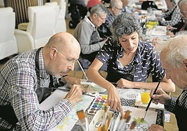 La arteterapeuta Evelyn Pelayo, durante una sesión junto a varios usuarios del centro de Asparbi para personas con párkinson avanzado.